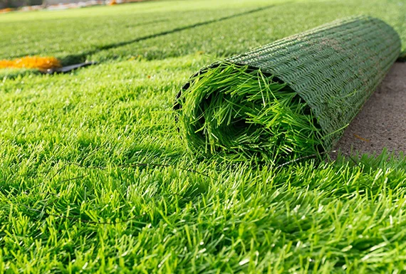 Roll of artificial grass showcasing the benefits of a year-round green and low-maintenance lawn in Peoria.